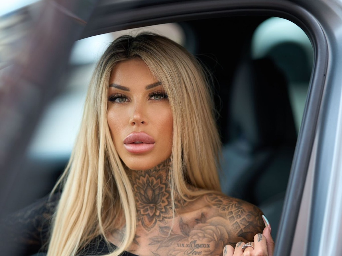 Zu sehen ist die Erotik-Influencerin Jacky Inked bei einem Fotoshooting in einem Auto.