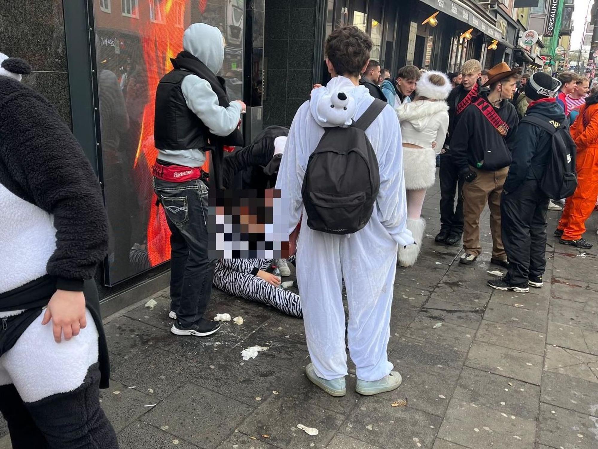 Junger Mann sitzt auf dem Boden und hat sich übergeben.