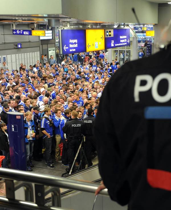 Fans von Schalke 04 warten am Hauptbahnhof und werden von der Polizei beobachtet.