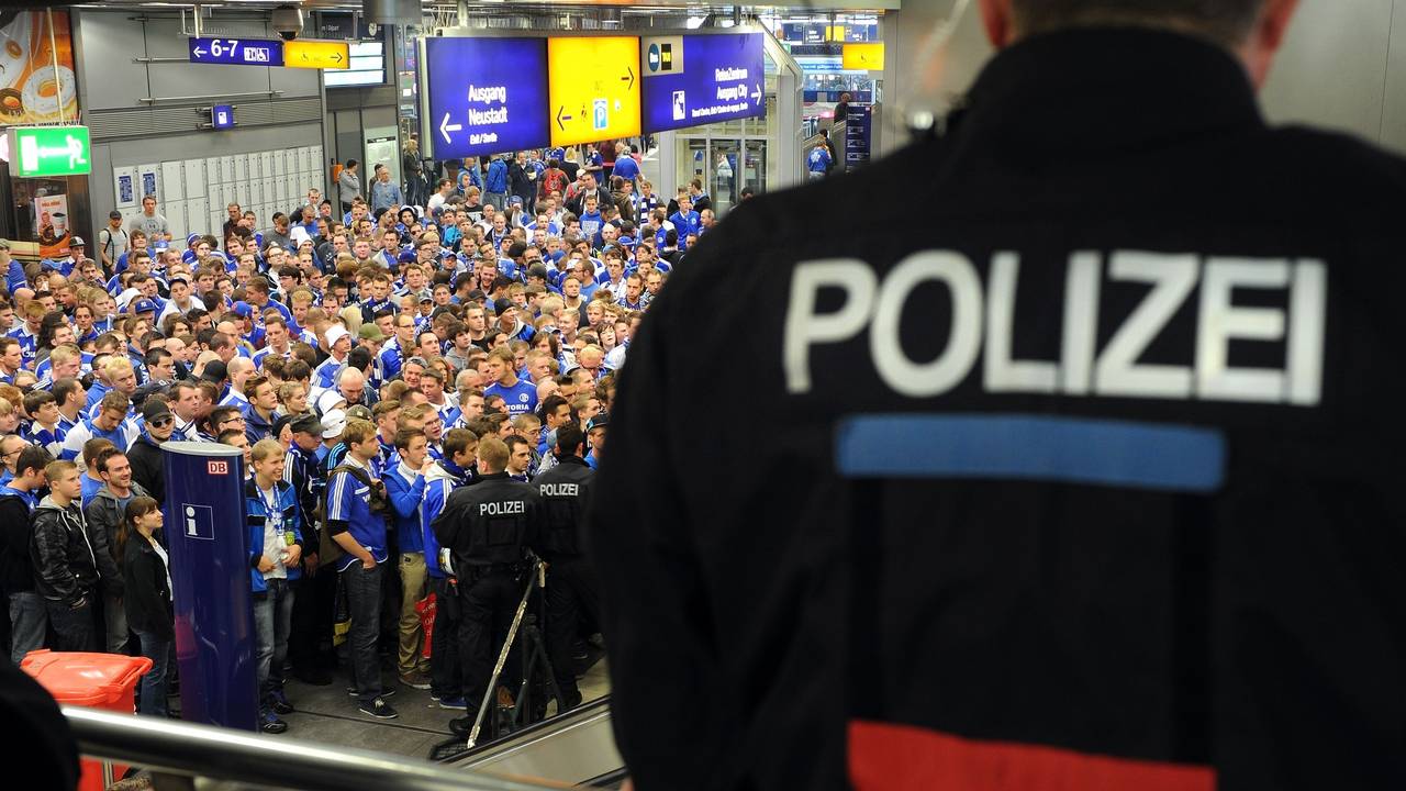 Fans von Schalke 04 warten am Hauptbahnhof und werden von der Polizei beobachtet.
