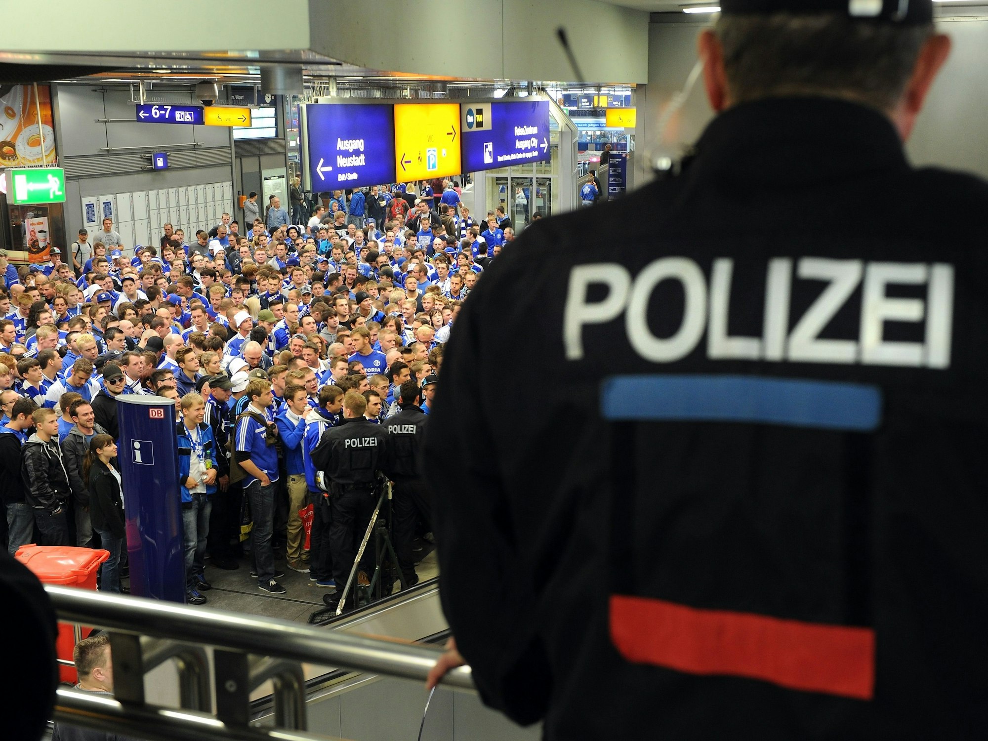Fans von Schalke 04 warten am Hauptbahnhof und werden von der Polizei beobachtet.