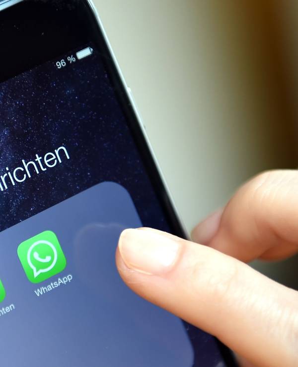 Auf dem Display eines iphone werden die Symbole der Apps „WhatsApp“ angezeigt.