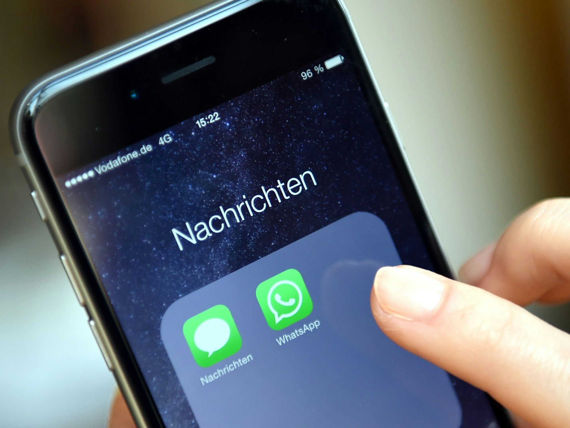 Auf dem Display eines iphone werden die Symbole der Apps „WhatsApp“ angezeigt.