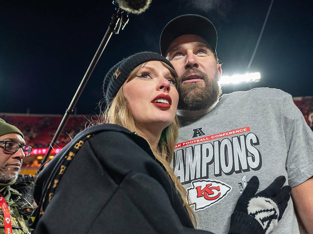 Travis Kelce und Taylor Swift liegen sich in den Armen.