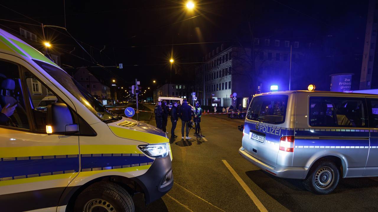 Einsatzfahrzeuge der Polizei stehen an einem Tatort, ein Bereich ist abgesperrt.