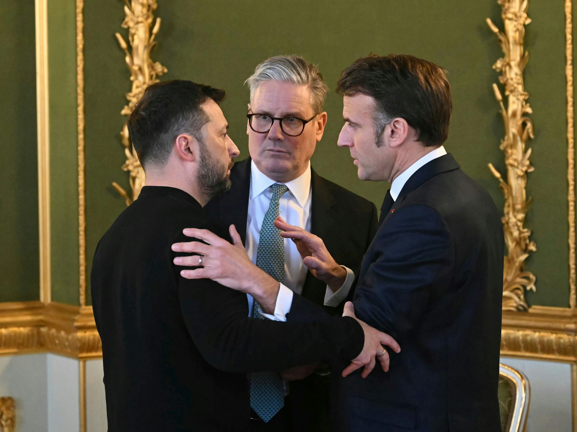Der britische Premier Sir Keir Starmer (M.), der ukrainische Präsident Wolodymyr Selenskyj (l.) und der französische Präsident Emmanuel Macron unterhalten sich am 2. März 2025 während des Gipfeltreffens der europäischen Staats- und Regierungschefs zur Lage der Ukraine im Lancaster House.