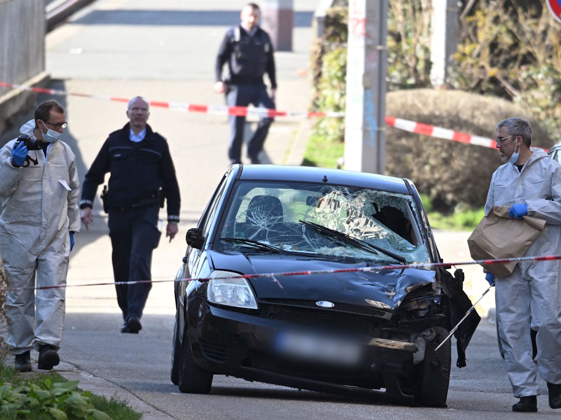 Beamte der Spurensicherung untersuchen nach einer Todesfahrt das beschädigte Fahrzeug an einer Zufahrt zur Rheinbrücke.