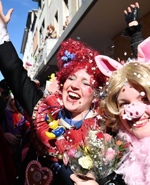 Eine Frau ist als Schwein verkleidet, neben ihr reißt eine andere verkleidete Frau den Arm vor Begeisterung hoch.