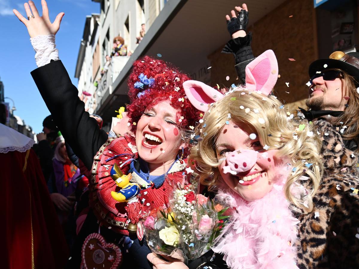 Eine Frau ist als Schwein verkleidet, neben ihr reißt eine andere verkleidete Frau den Arm vor Begeisterung hoch.