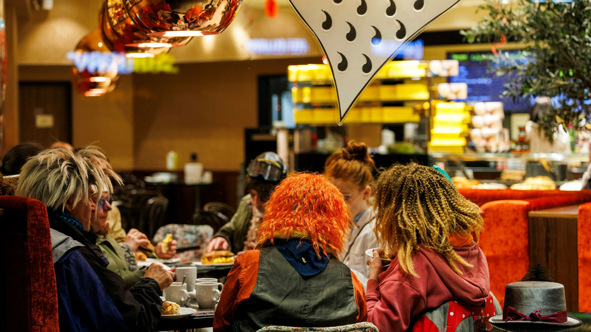 In einer Bäckerei sitzen schon am frühen Morgen die ersten Kanevalisten und Karnevalistinnen, die sich für den Rosenmontagszug stärken.