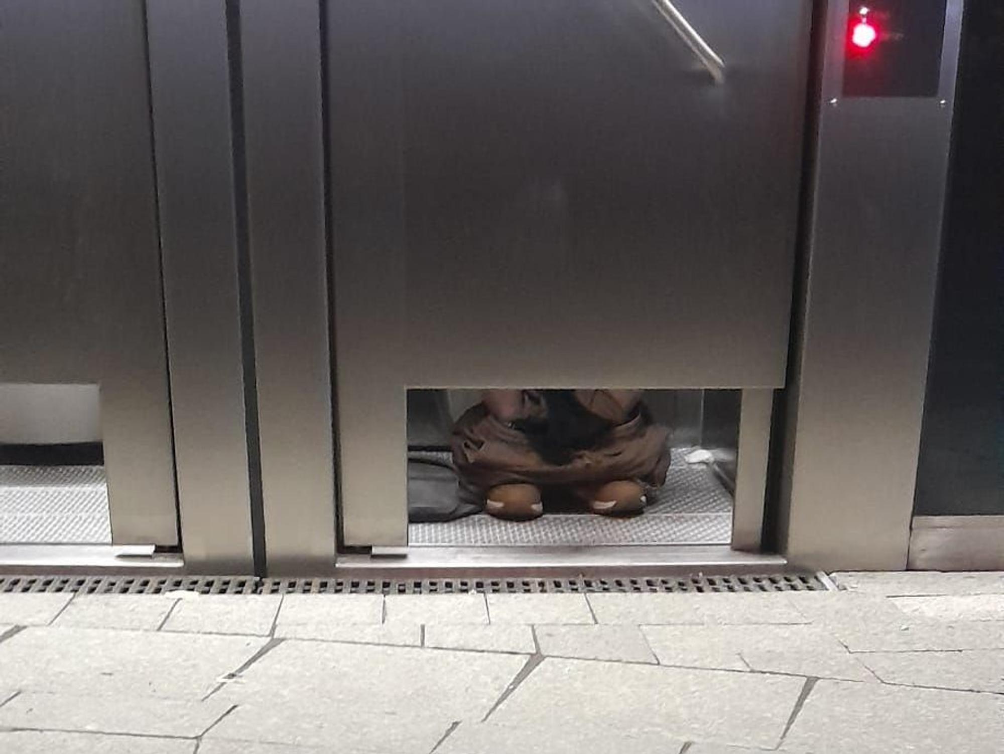 An einer öffentlichen Toilette in Köln sieht man die Füße eines Nutzers.
