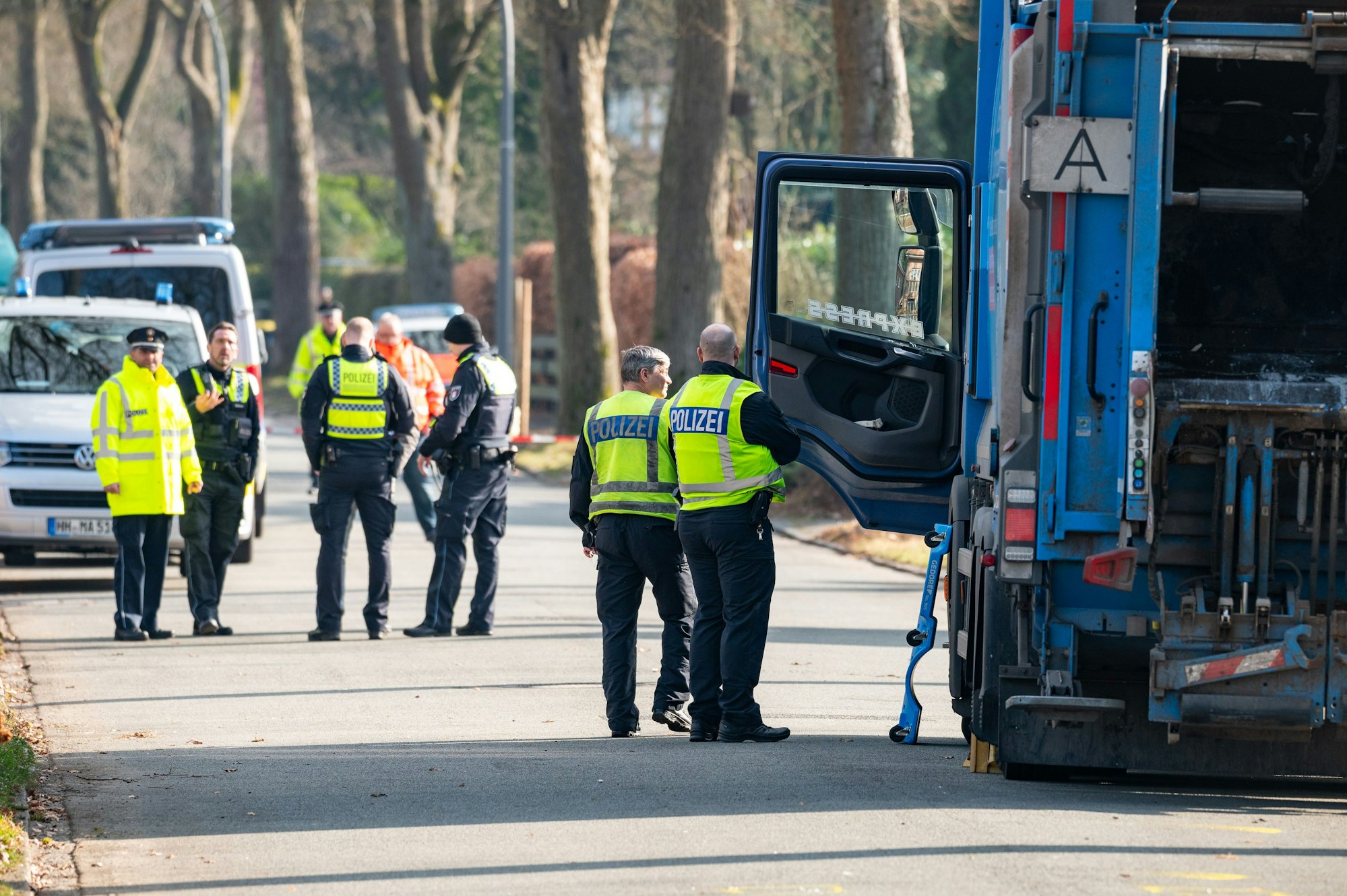 Polizisten ermitteln an dem Müllwagen am Unfallort. Ein Kind ist in Hamburg nach Angaben der Feuerwehr von einem Müllfahrzeug überfahren und tödlich verletzt worden.