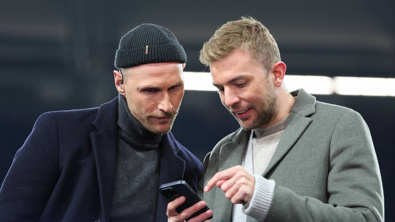 Benedikt Höwedes und Christoph Kramer gucken zusammen auf ein Handy.