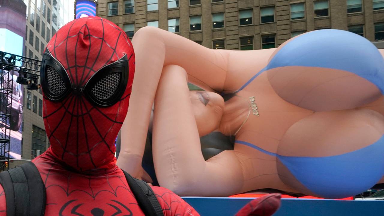 Zu sehen ist ein Spiderman-Maskottchen welches am 04.03.2025 am Times Square in New York vor einer 20 Meter großen Kim Kardashian Ballon-Puppe posiert.