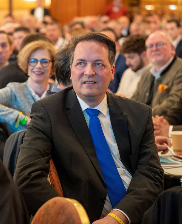 Karl Alexander Mandl sitzt bei einem Vortrag im Publikum und hört zu.