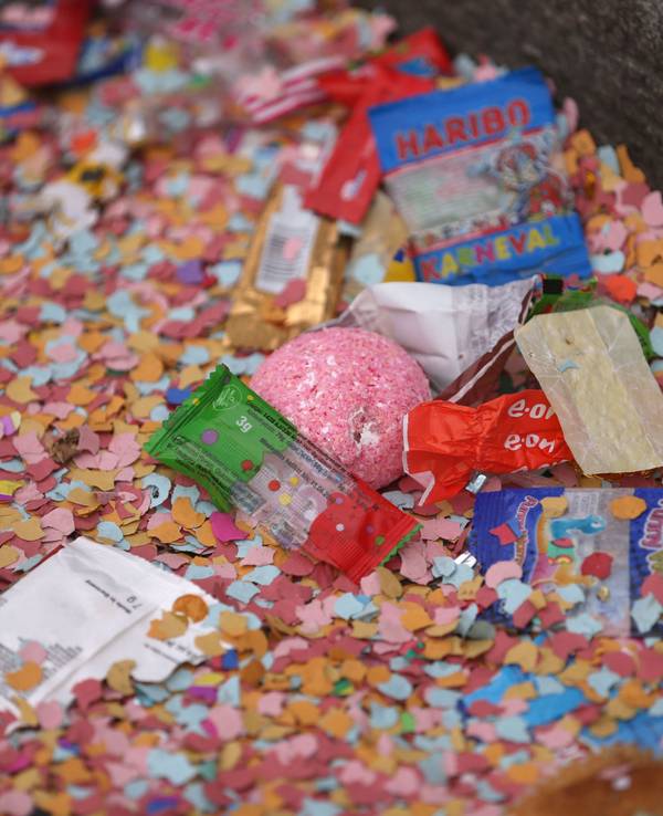 Konfetti und Kamelle liegen nach dem Rosenmontagsumzug auf dem Boden.