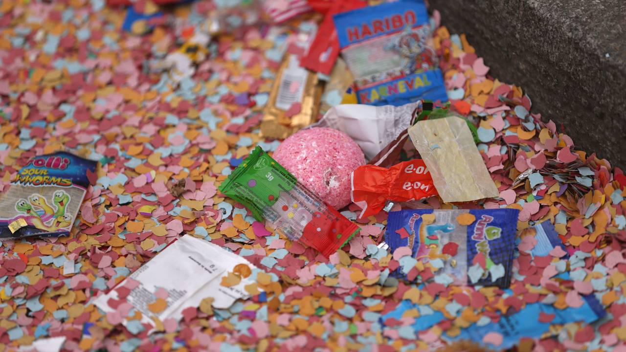 Konfetti und Kamelle liegen nach dem Rosenmontagsumzug auf dem Boden.
