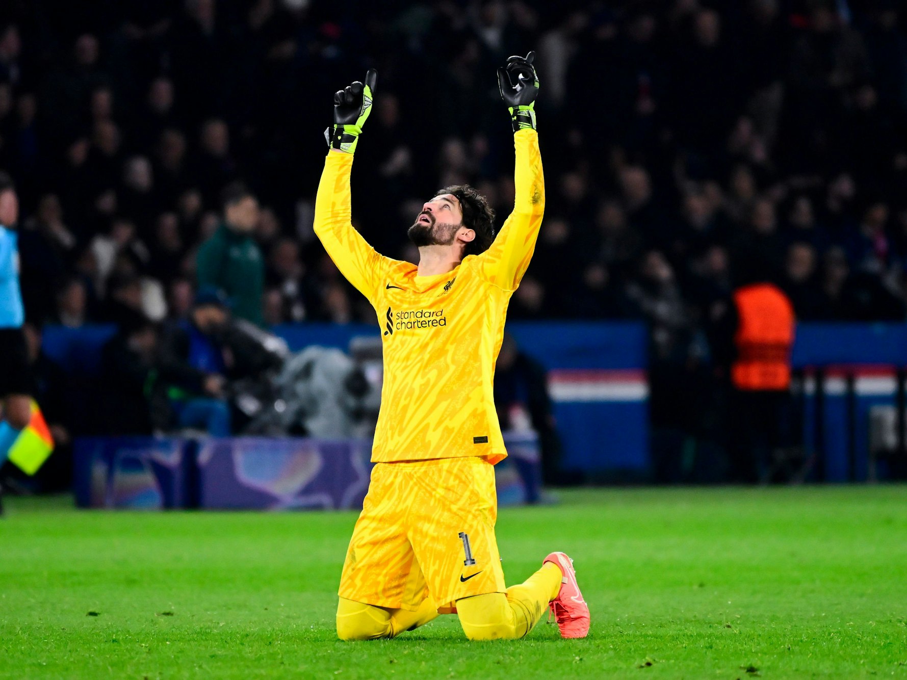 Alisson Becker kniet auf dem Rasen und betet.