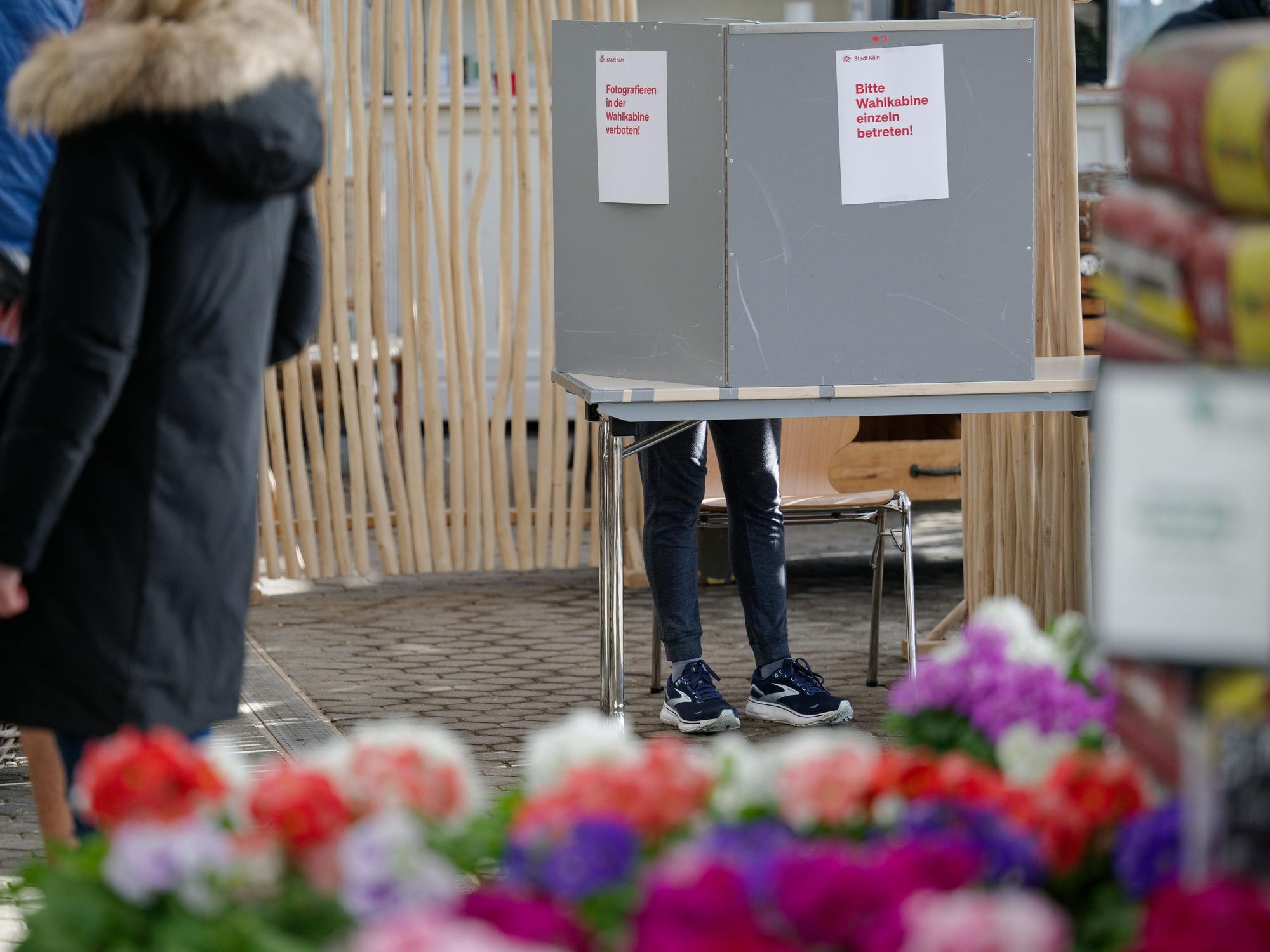 Eine Frau steht in einem Wahllokal in einem Gewächshaus eines Gartenbaubetriebs in Köln-Hahnwald hinter einer Wahlkabine: Das BSW scheiterte knapp an der Fünf-Prozent-Hürde. Nun vermutet die Partei, dass mehr Menschen für sie gestimmt haben könnten.