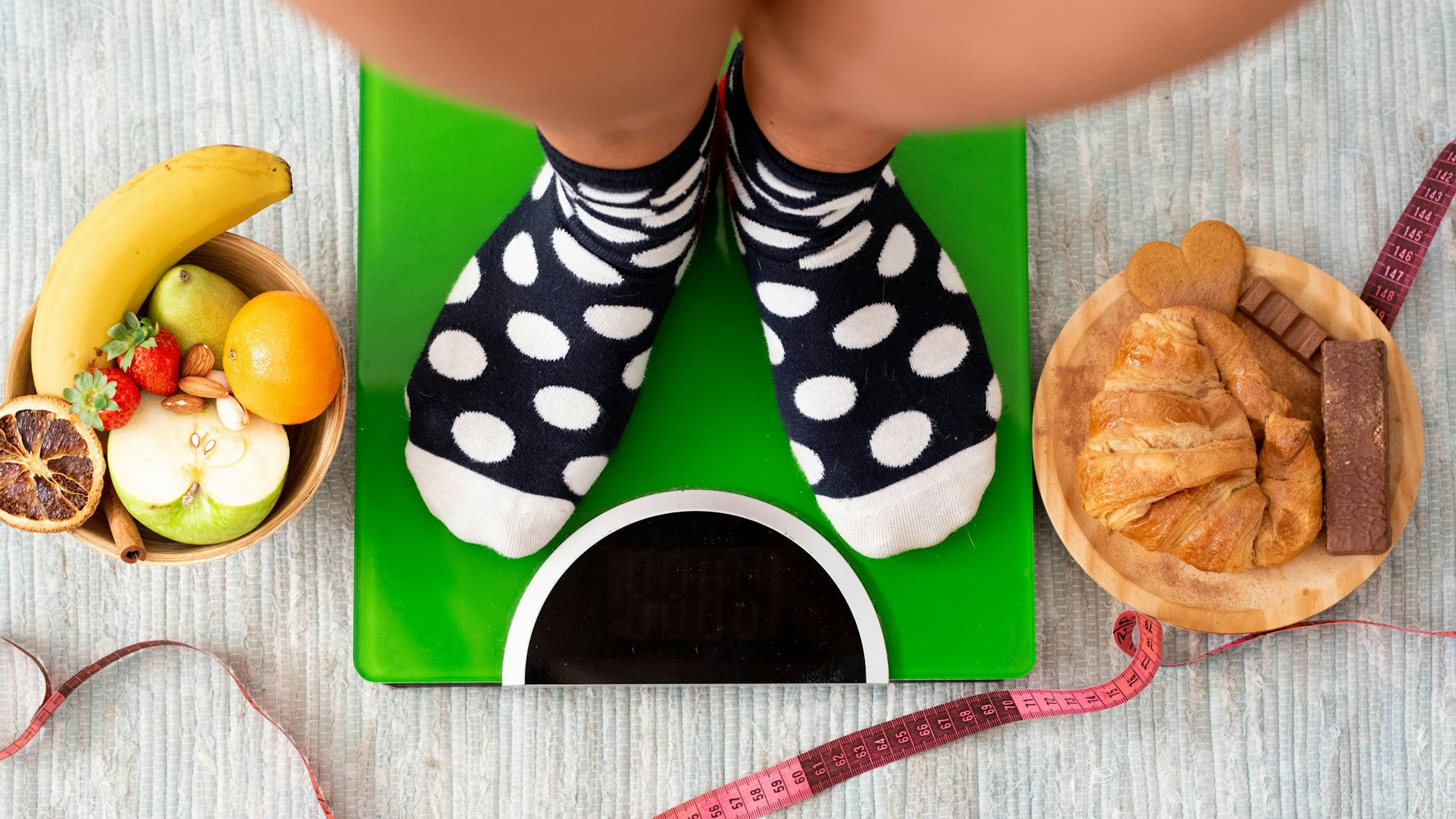 Mensch mit Strümpfen auf einer Waage