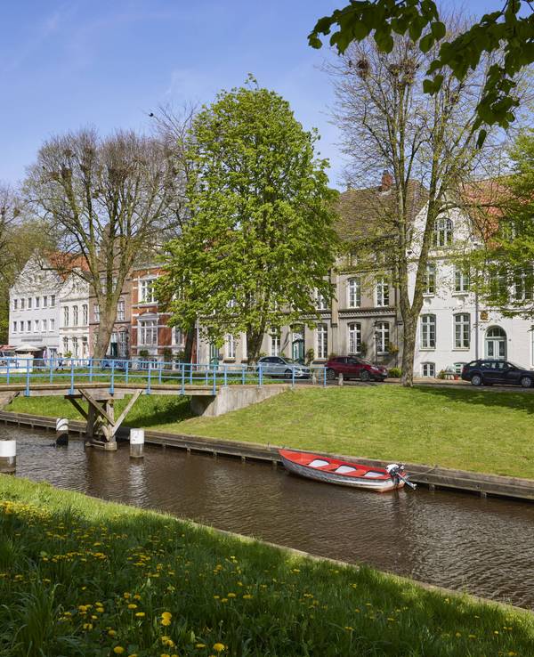 Zu sehen sind Häuser und eine Brücke am Mittelburggraben in Friedrichstadt, Kreis Nordfriesland, Schleswig-Holstein, Deutschland.