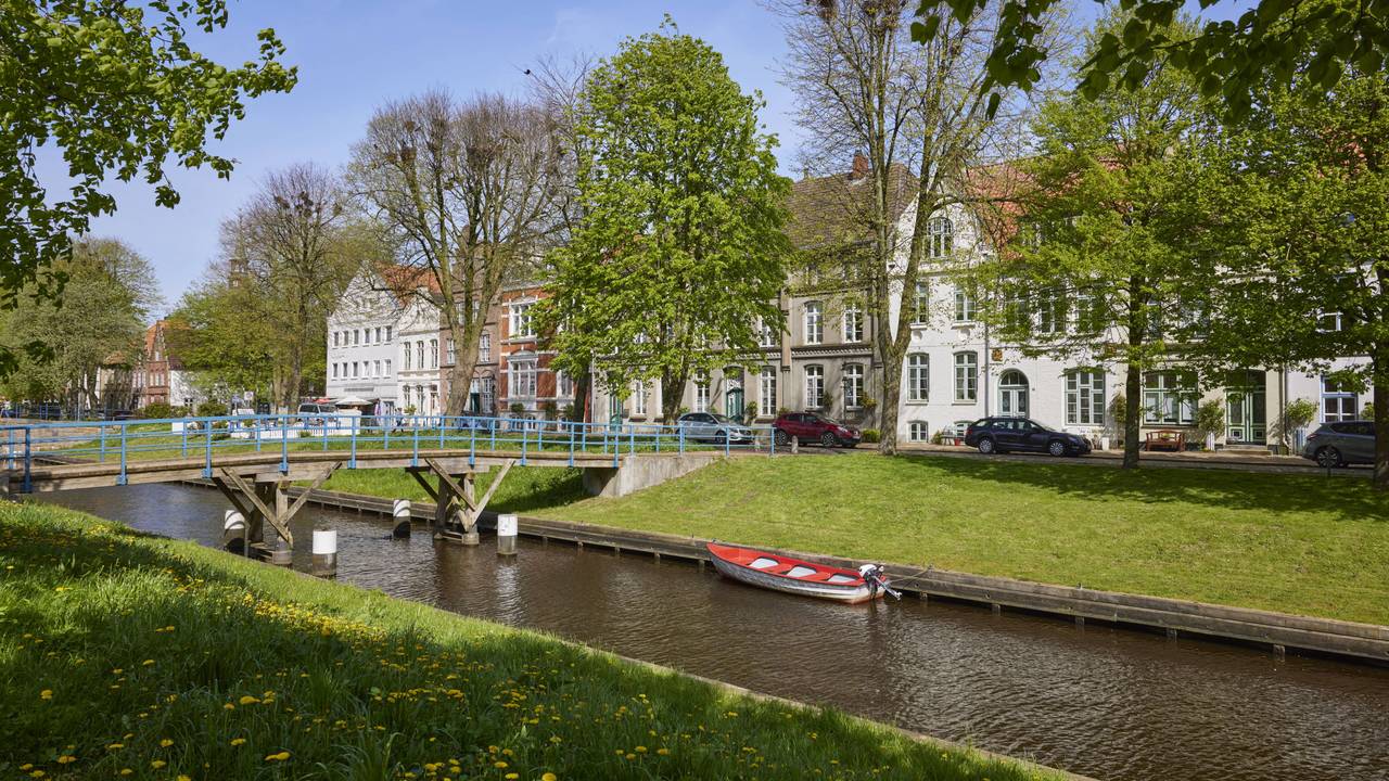 Zu sehen sind Häuser und eine Brücke am Mittelburggraben in Friedrichstadt, Kreis Nordfriesland, Schleswig-Holstein, Deutschland.