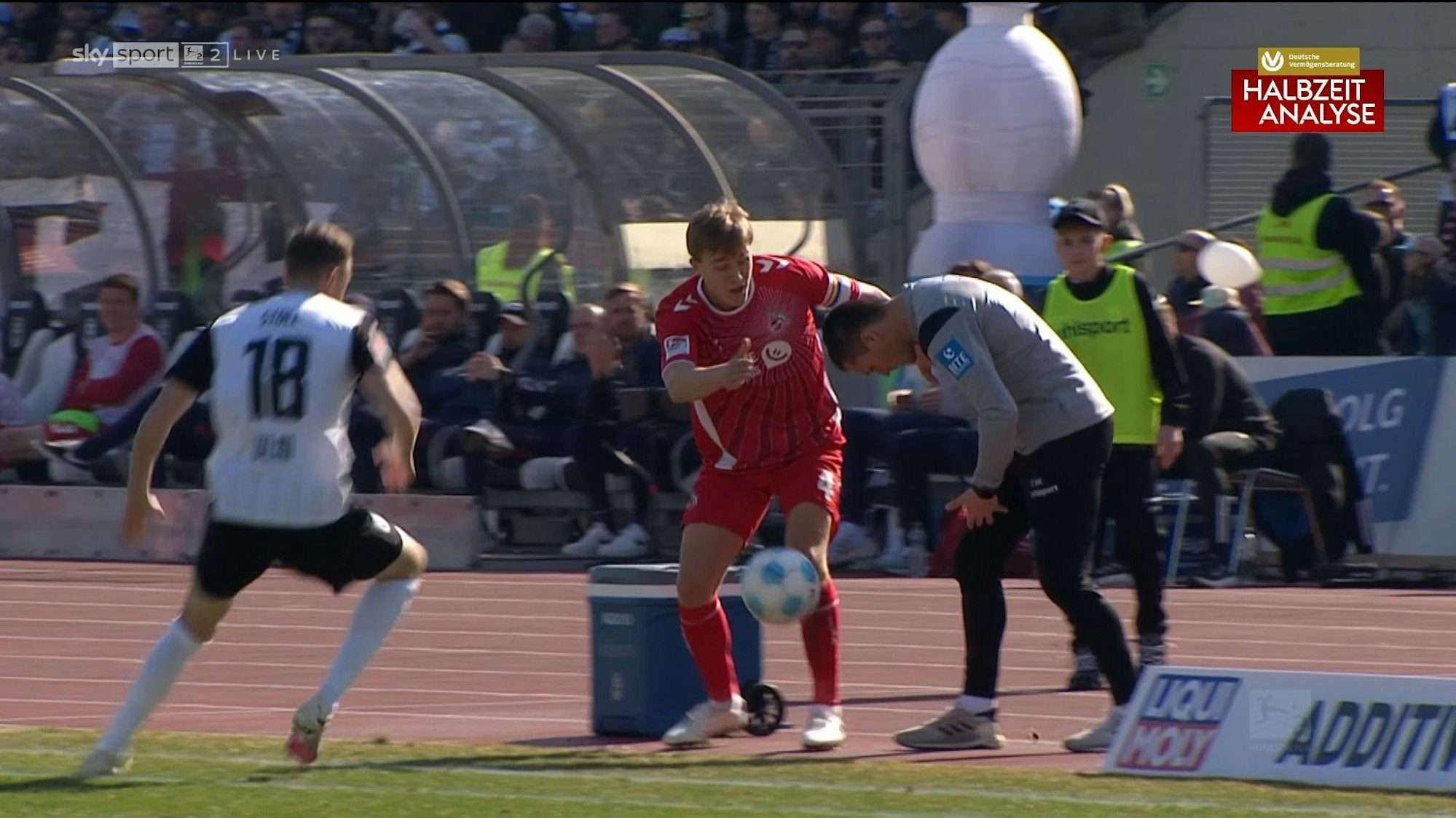 Timo Hübers fängt sich nach dem gerade noch verhinderten Zusammenprall mit Ulm-Trainer Thomas Wörle auf.