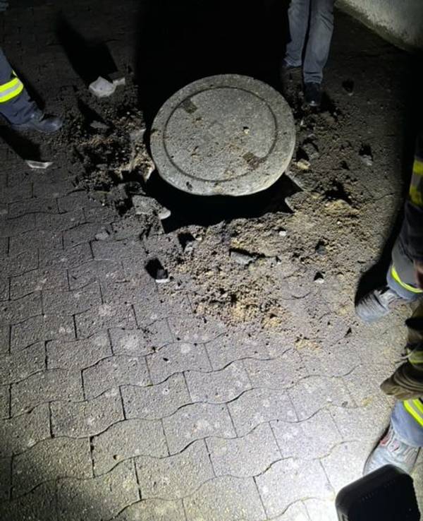 Einsatzkräfte begutachten einen Gullydeckel. Zu einer heftigen Explosion ist es in der Nähe einer Schule im ostwestfälischen Vlotho gekommen. Auf einer Strecke von mehreren Hundert Metern seien Gullydeckel in die Luft geflogen, Fensterscheiben hätten vibriert.