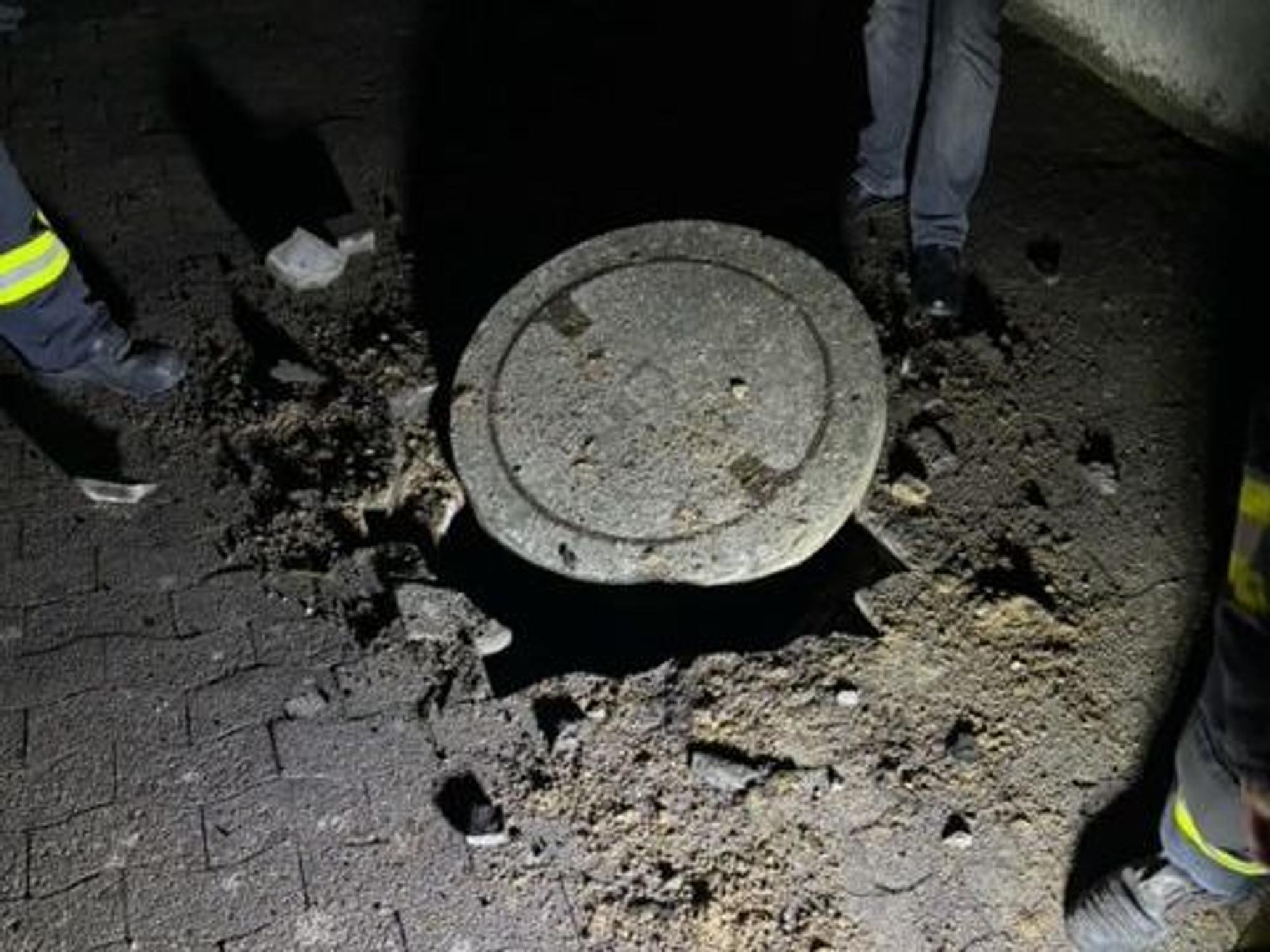 Einsatzkräfte begutachten einen Gullydeckel. Zu einer heftigen Explosion ist es in der Nähe einer Schule im ostwestfälischen Vlotho gekommen. Auf einer Strecke von mehreren Hundert Metern seien Gullydeckel in die Luft geflogen, Fensterscheiben hätten vibriert.