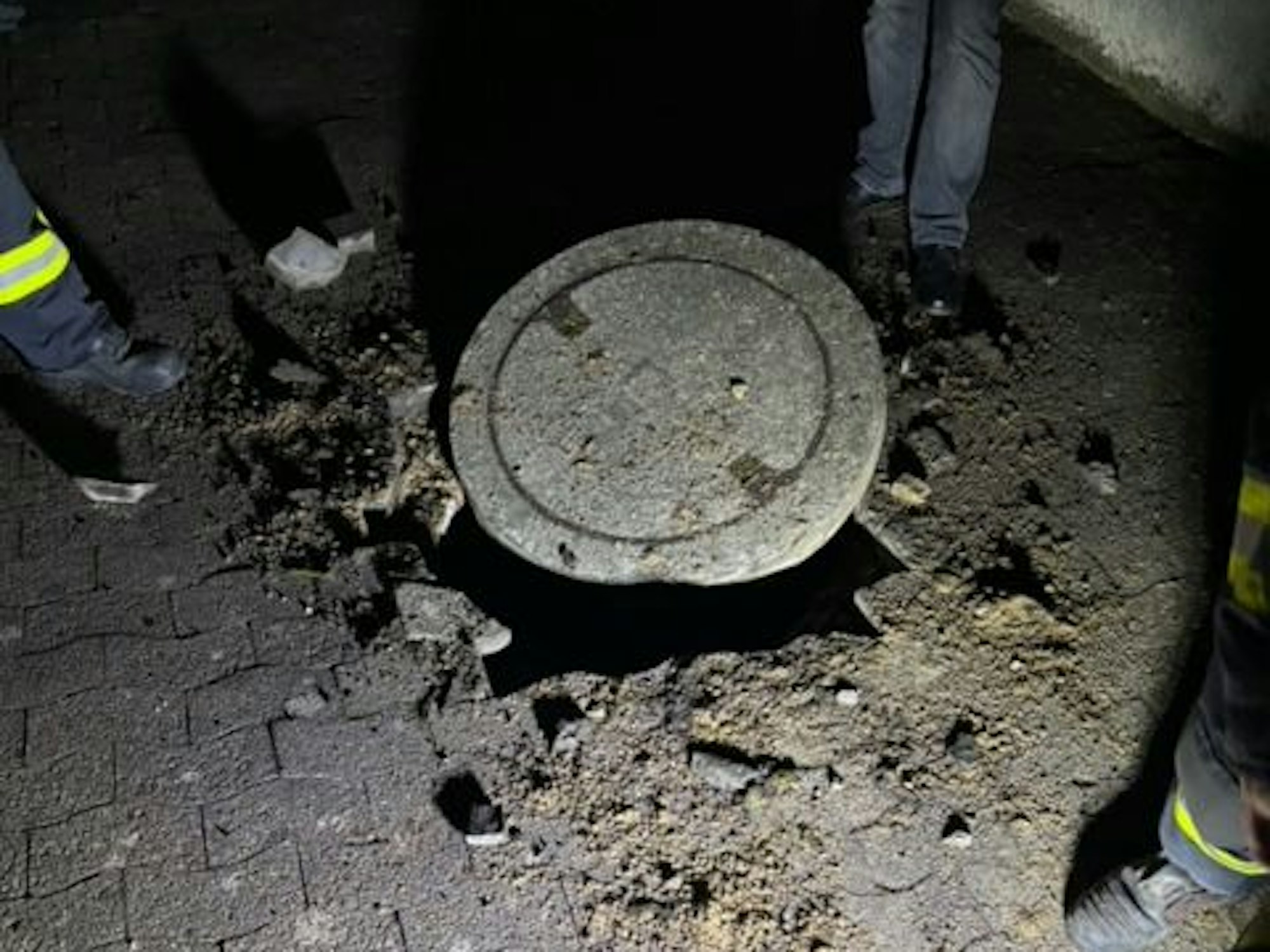 Einsatzkräfte begutachten einen Gullydeckel. Zu einer heftigen Explosion ist es in der Nähe einer Schule im ostwestfälischen Vlotho gekommen. Auf einer Strecke von mehreren Hundert Metern seien Gullydeckel in die Luft geflogen, Fensterscheiben hätten vibriert.