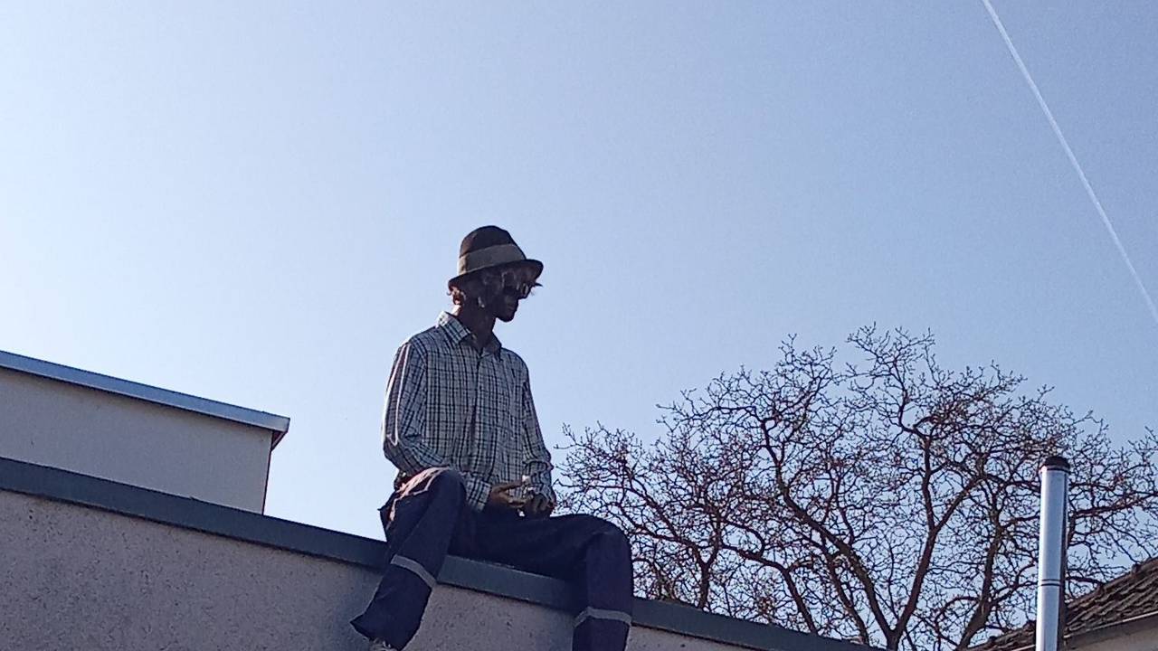 Eine Puppe sitzt auf einem Dach