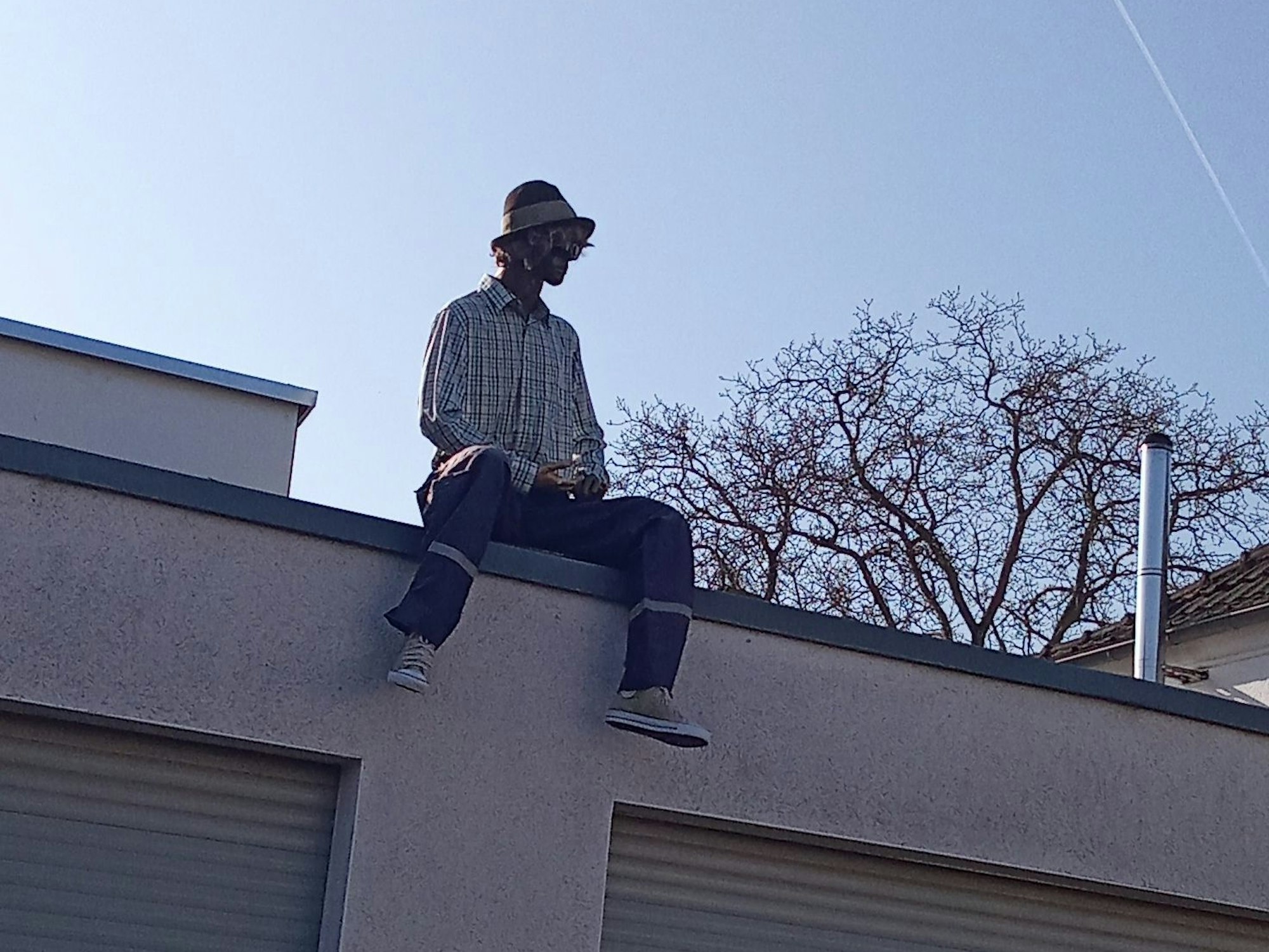 Eine Puppe sitzt auf einem Dach