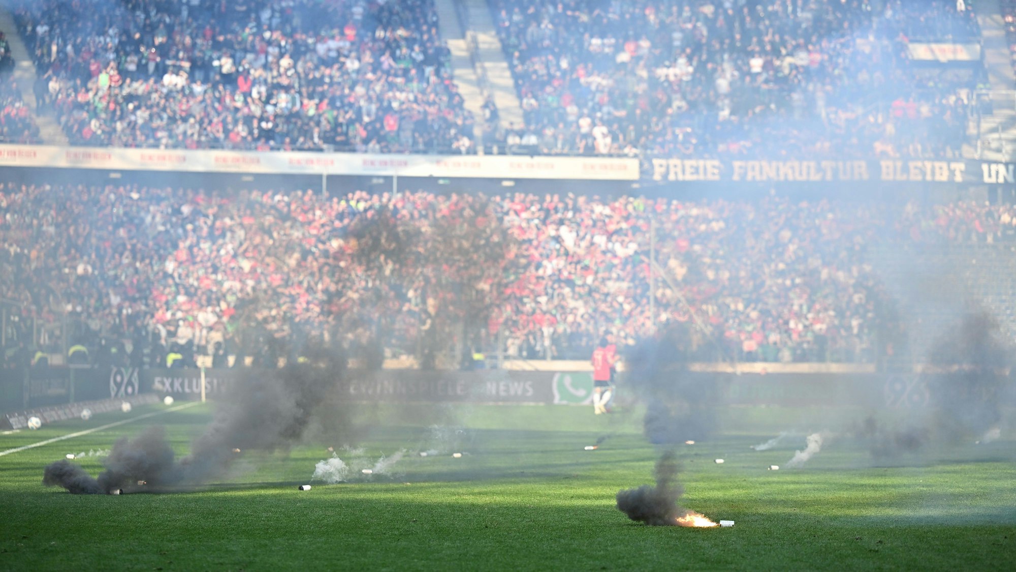 Zahlreiche Rauchtöpfe beim Zweitliga-Derby zwischen Hannover 96 und Eintracht Braunschweig auf dem Rasen.
