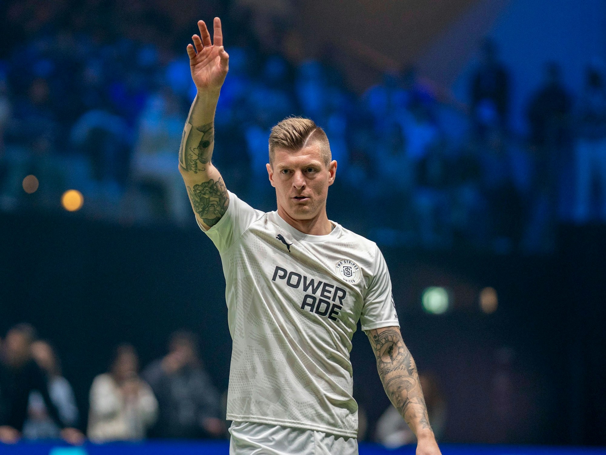 Toni Kroos hebt seine Hand in die Luft.