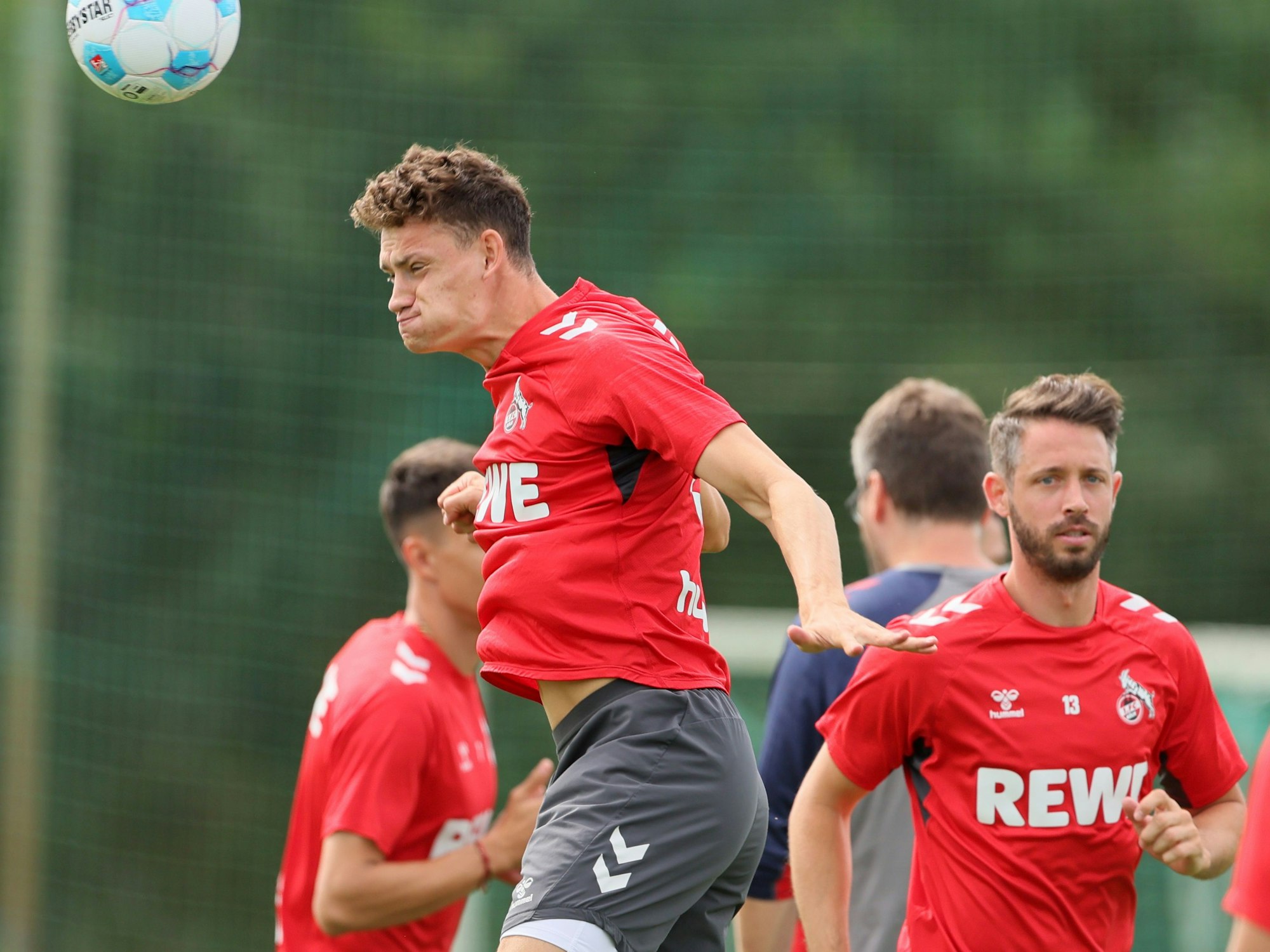 Eric Martel steigt im Training zum Kopfball hoch, dahinter läuft Mark Uth.