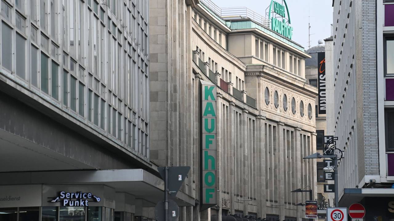 Eine Häuserreihen in der Kölner Innenstadt, an dem hinteren Gebäude hängen Schilder mit den Aufschriften Kaufhof und Galeria Kaufhof.