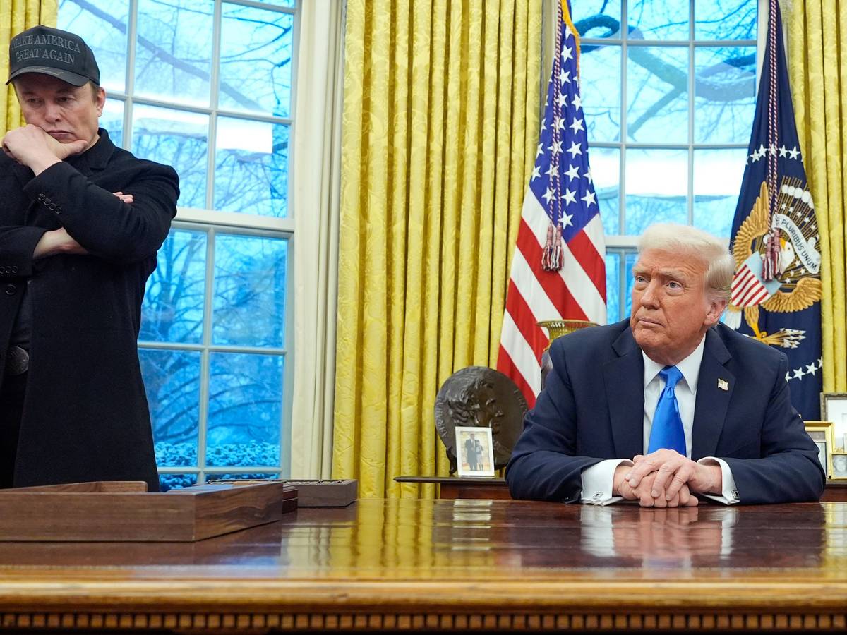 Elon Musk hört zu, während US-Präsident Donald Trump mit Reportern im Oval Office im Weißen Haus spricht.