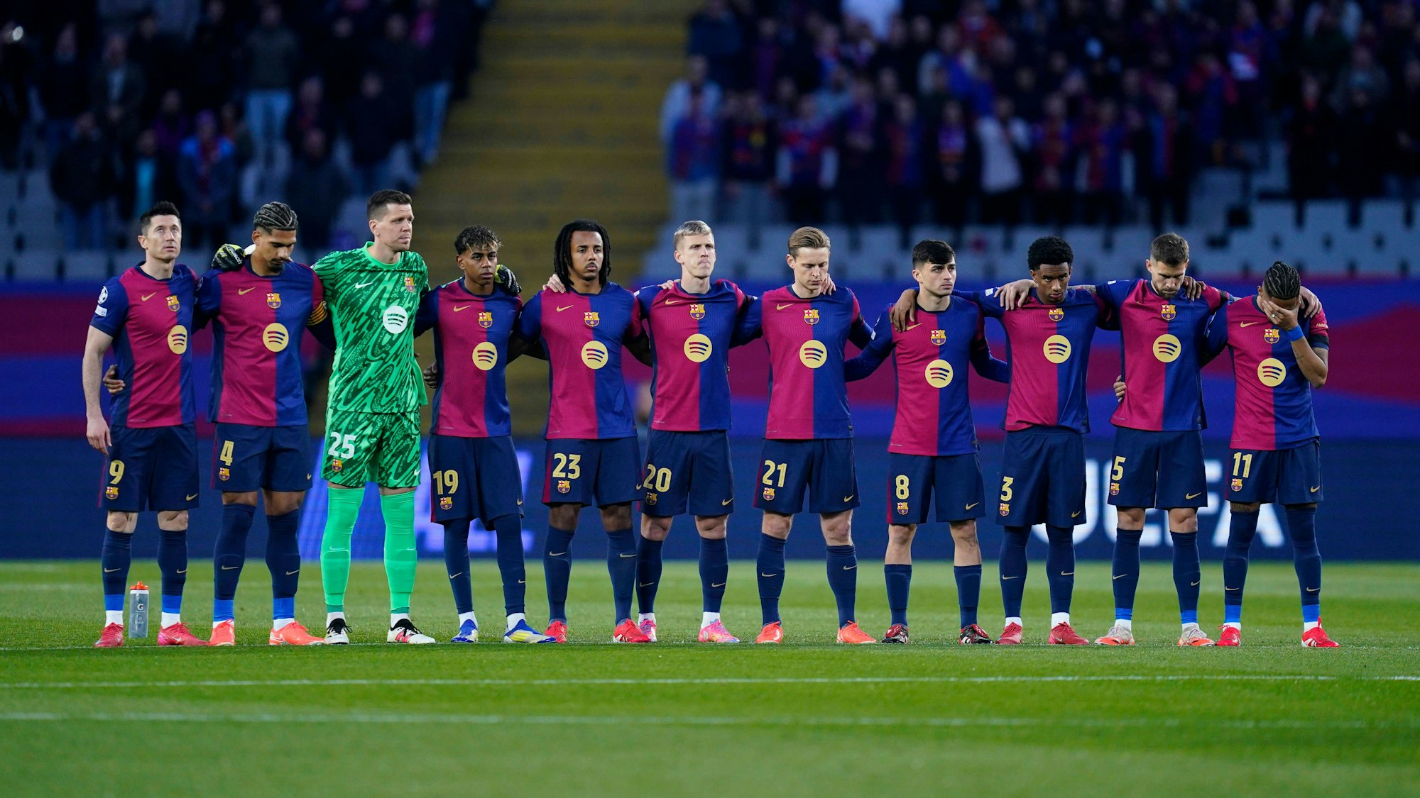 Die Spieler des FC Barcelona stehen in einer Reihe am Mittelkreis.