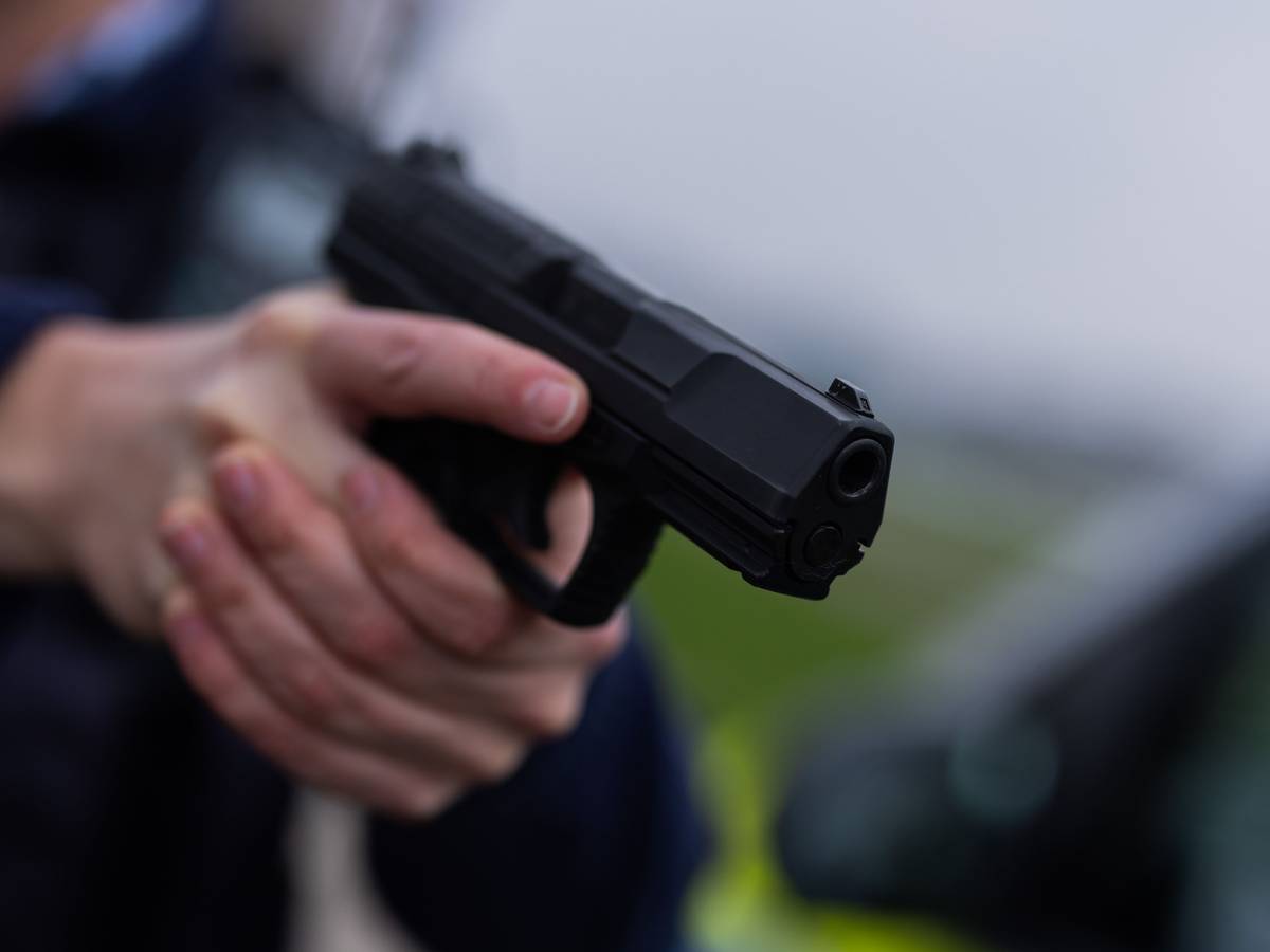Ein Polizist hält eine Pistole vom Typ Walther P99 in den Händen