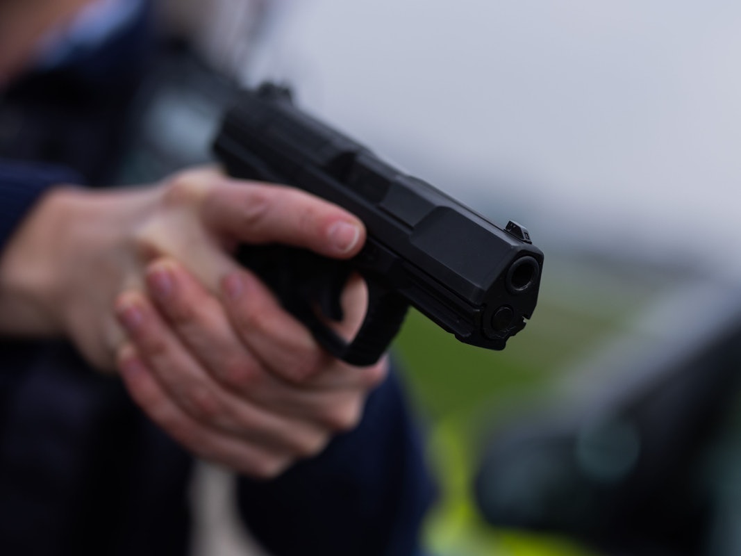 Ein Polizist hält eine Pistole vom Typ Walther P99 in den Händen