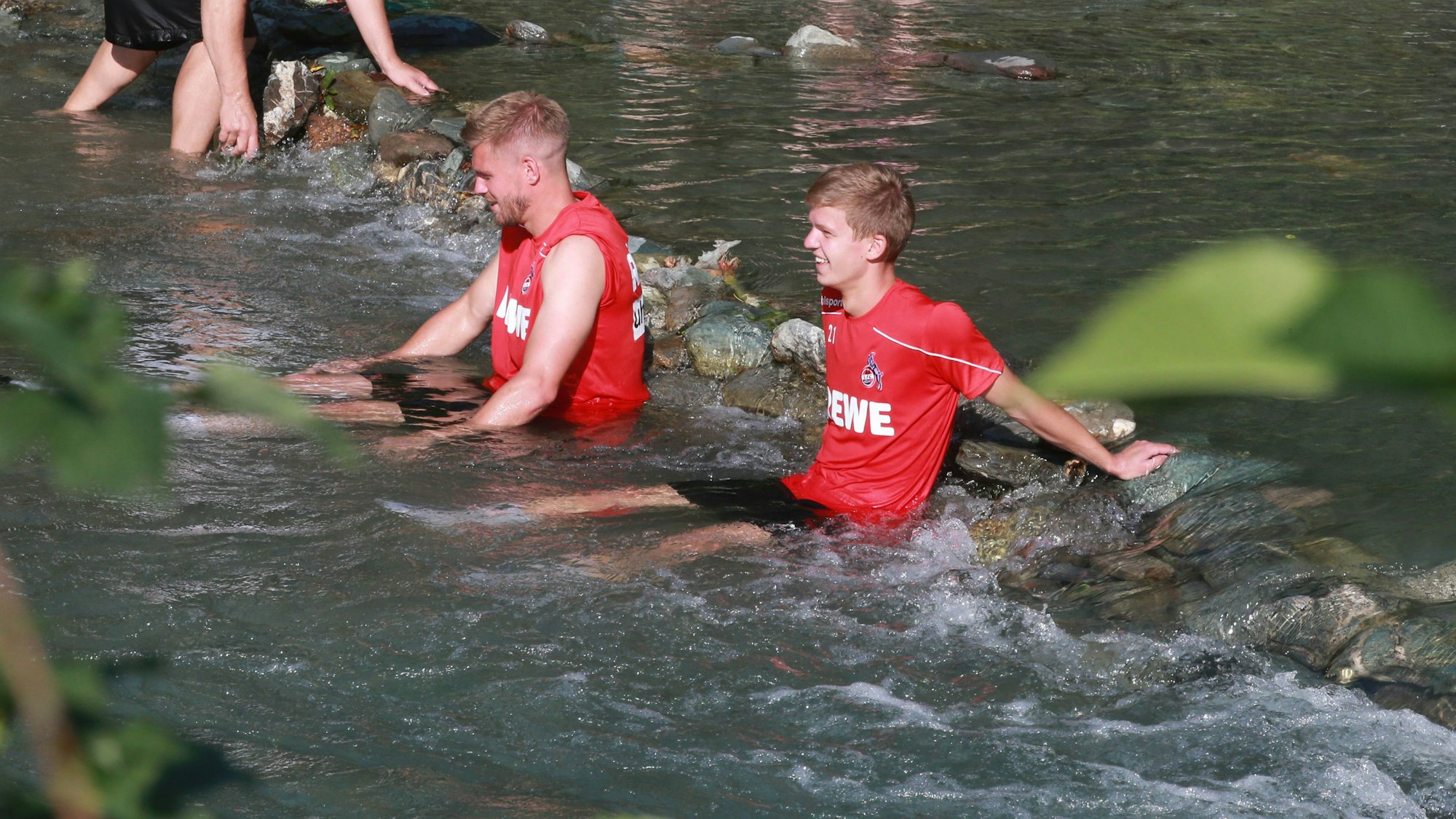 Vincent Koziello und Simon Terodde baden in einem Bach.
