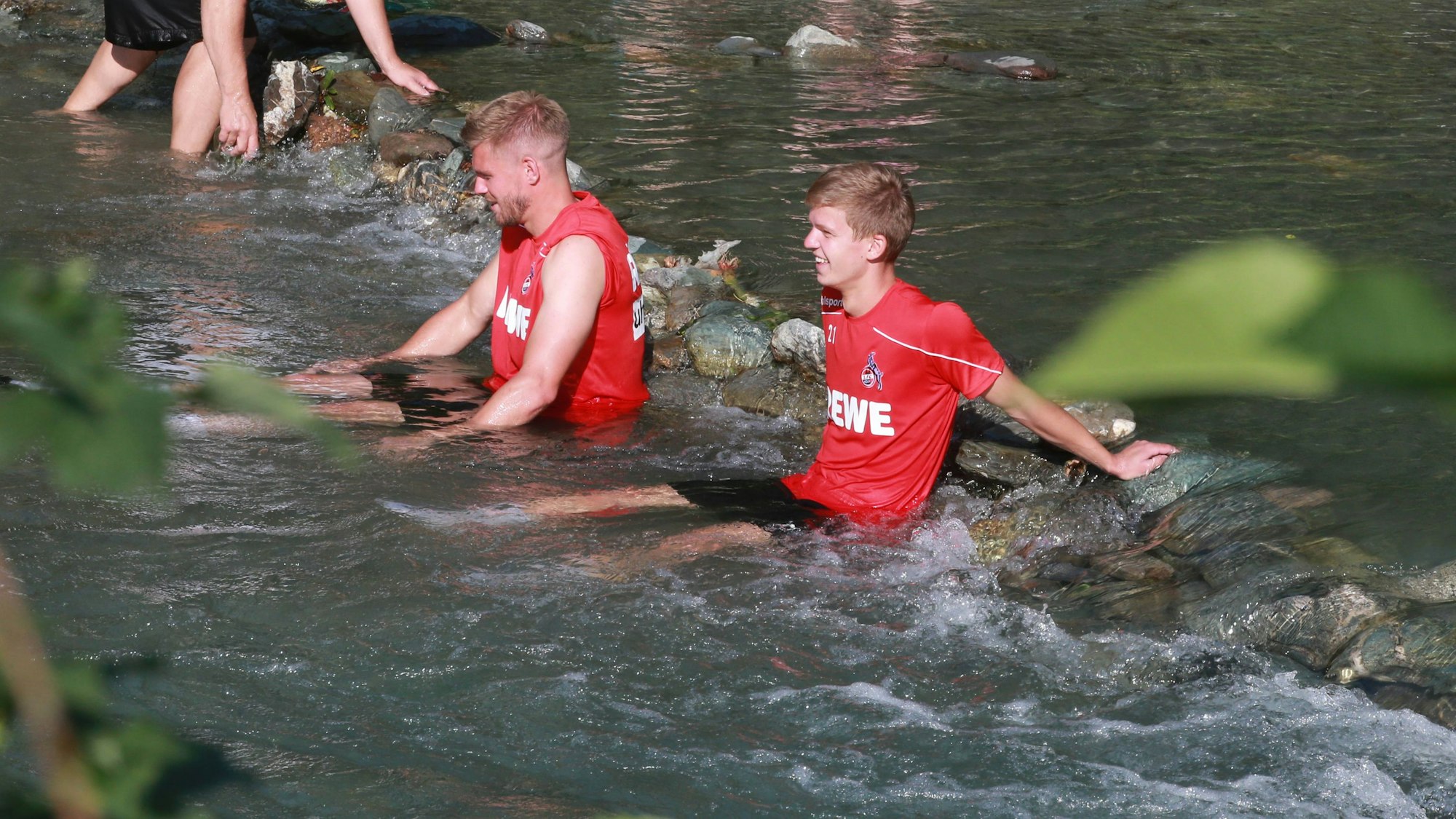 Vincent Koziello und Simon Terodde baden in einem Bach.