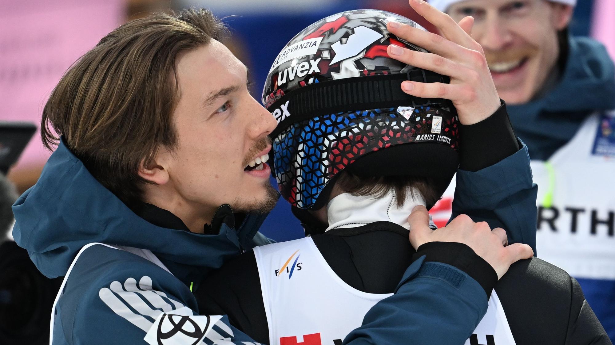Johann Andre Forfang (l) umarmt Marius Lindvik.