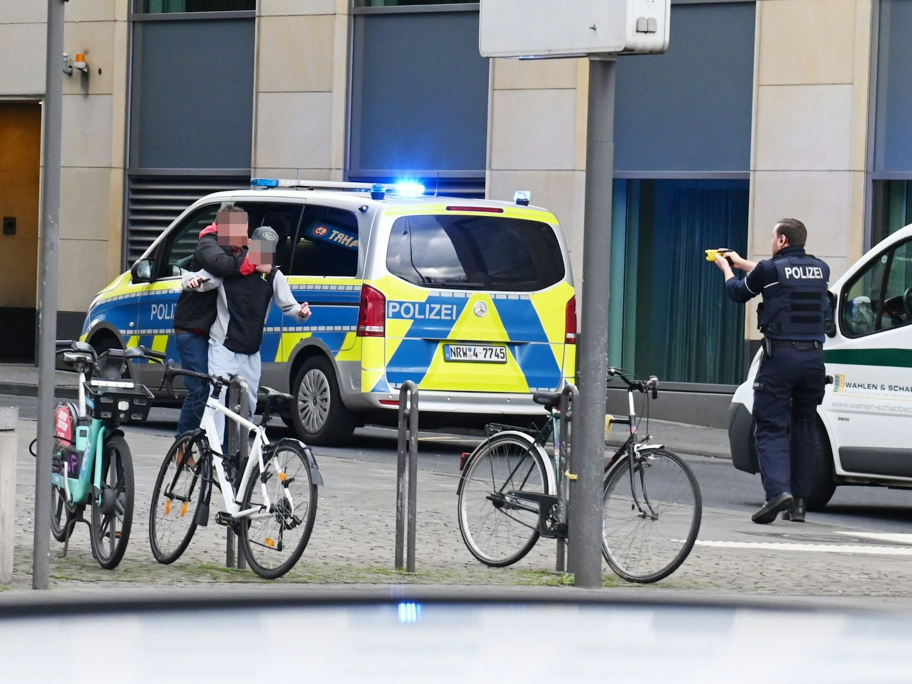 Ein Polizist richtet eine Waffe auf einen Mann.