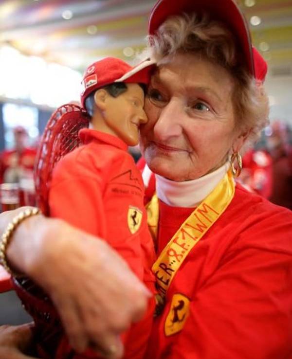 Erika Klütsch hält eine Puppe von Weltmeister Michael Schumacher im Arm.