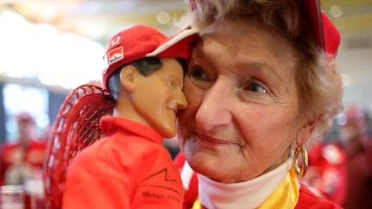 Erika Klütsch hält eine Puppe von Weltmeister Michael Schumacher im Arm.