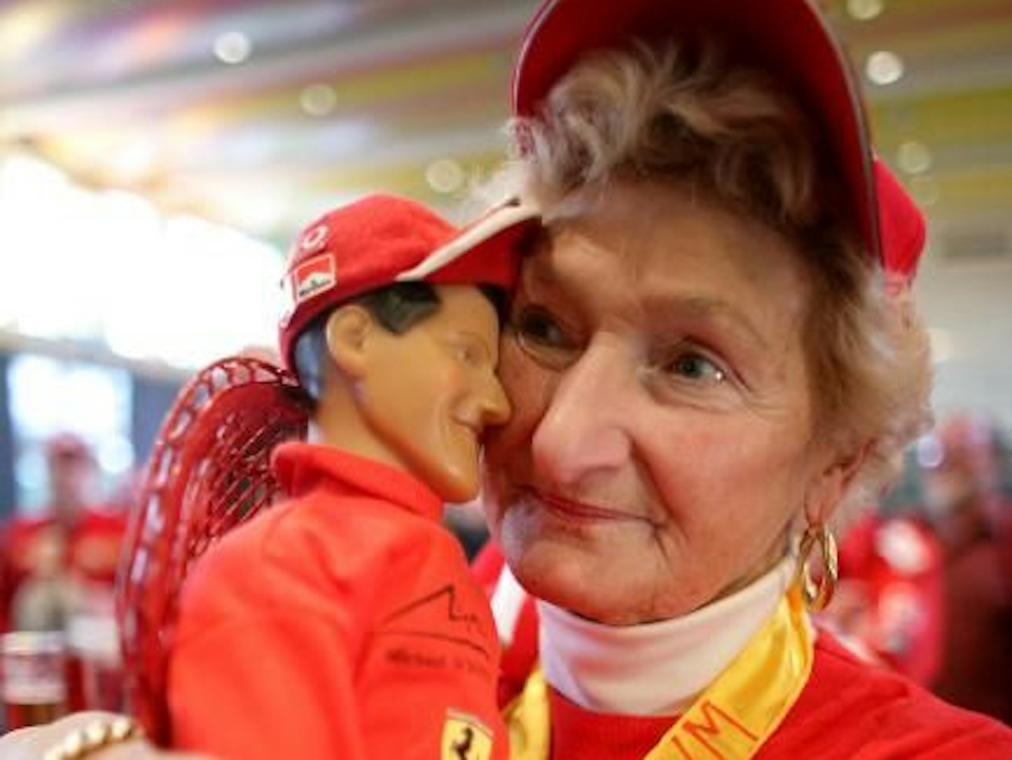 Erika Klütsch hält eine Puppe von Weltmeister Michael Schumacher im Arm.