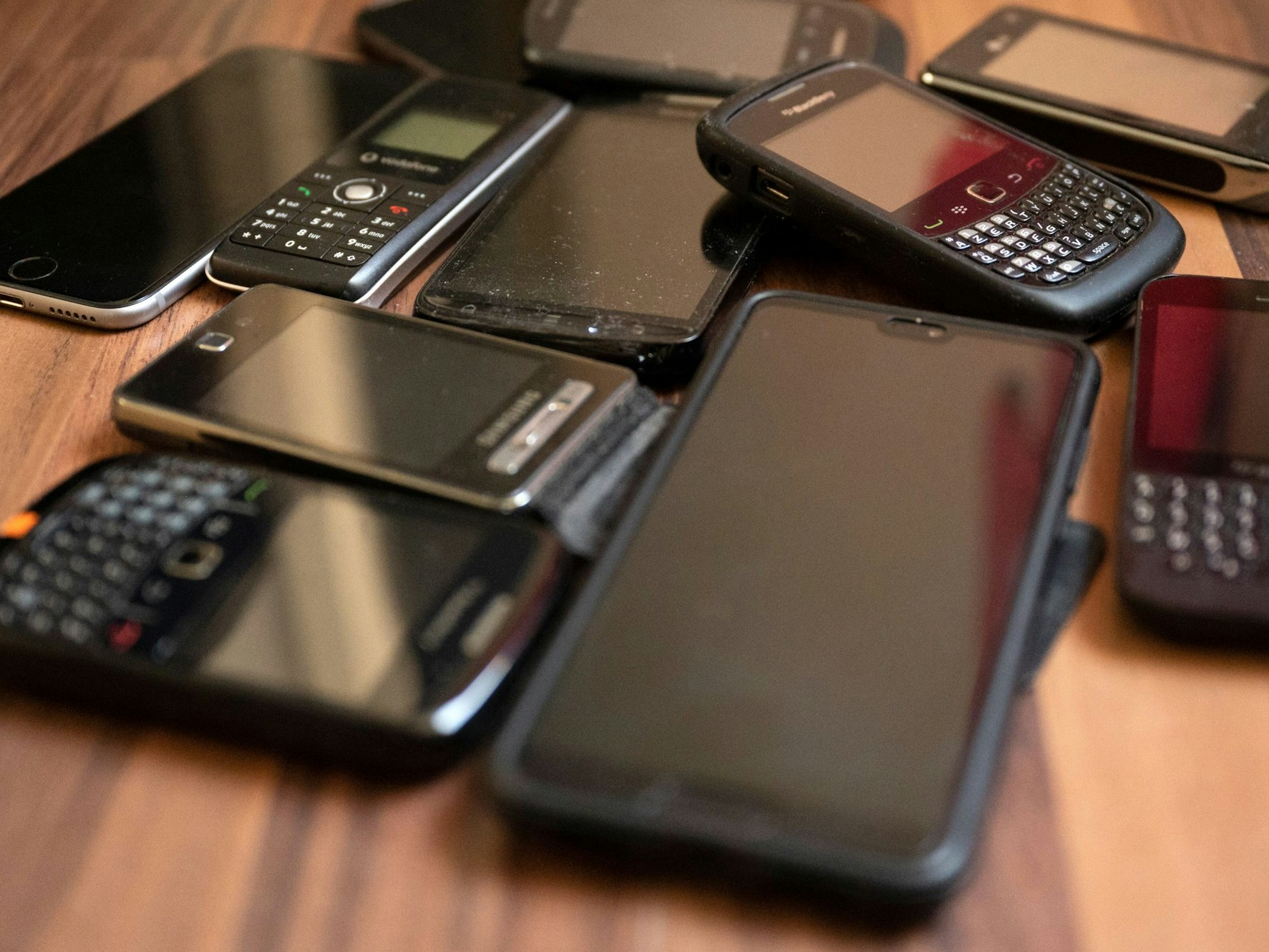 Alte Handys liegen auf einem Tisch. Es gibt Handys, die beim Warntag 2025 gar nicht auslösen können. Es betrifft normalerweise ältere Modelle.
