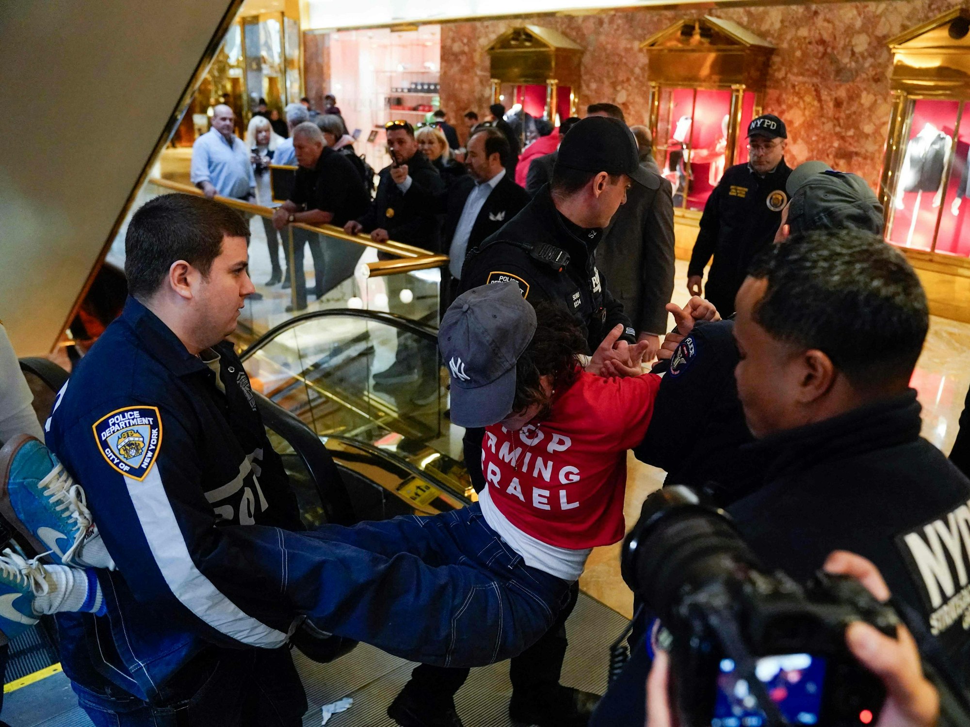Ein Demonstrant der Menschenrechtsorganisation „Jüdische Stimme für den Frieden“ wird von der Polizei im Trump Tower in New York am 13. März 2025 festgehalten.