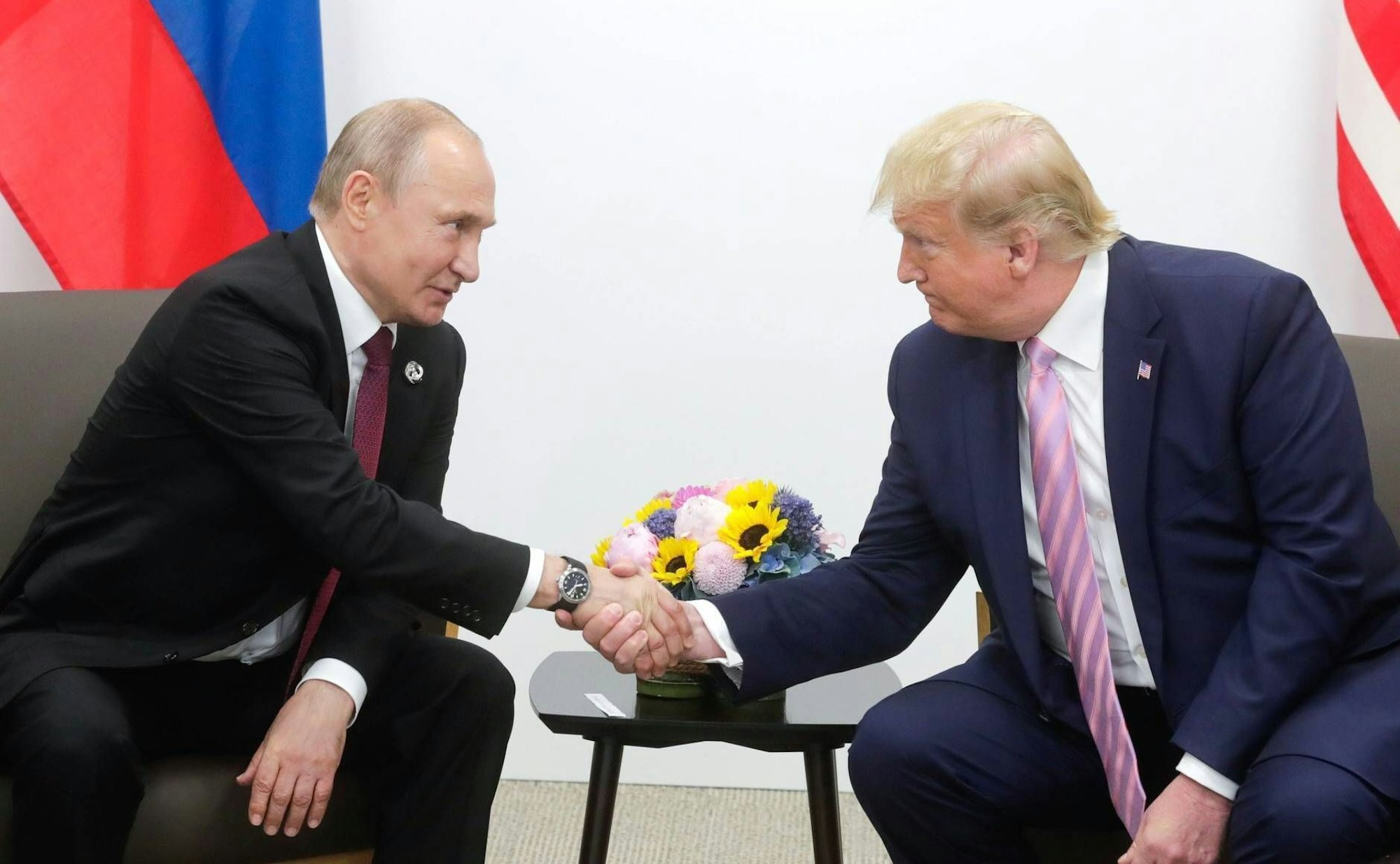 Donald Trump schüttelt die Hand von Wladimir Putin.